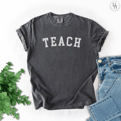 Dark grey t-shirt with 'TEACHER' text on a white background.