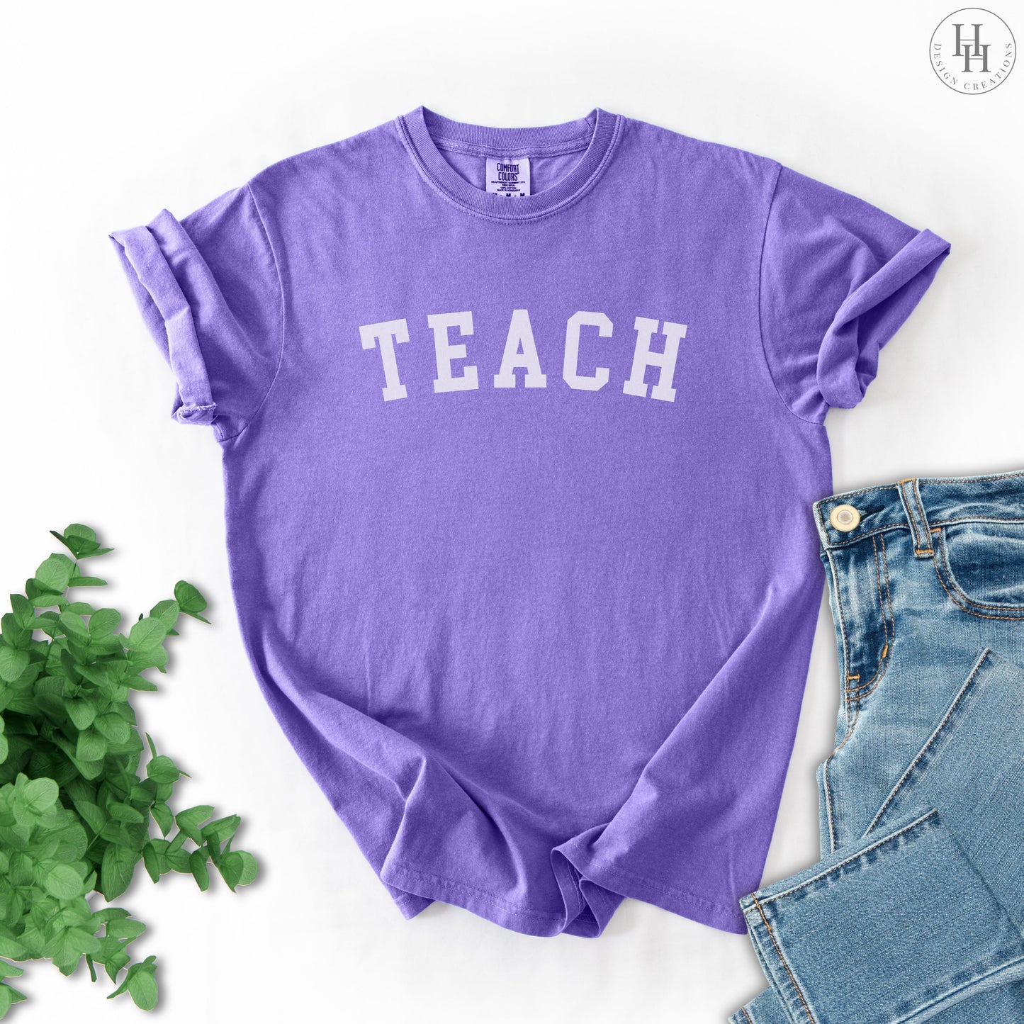 Violet t-shirt with 'TEACH' text on a white background