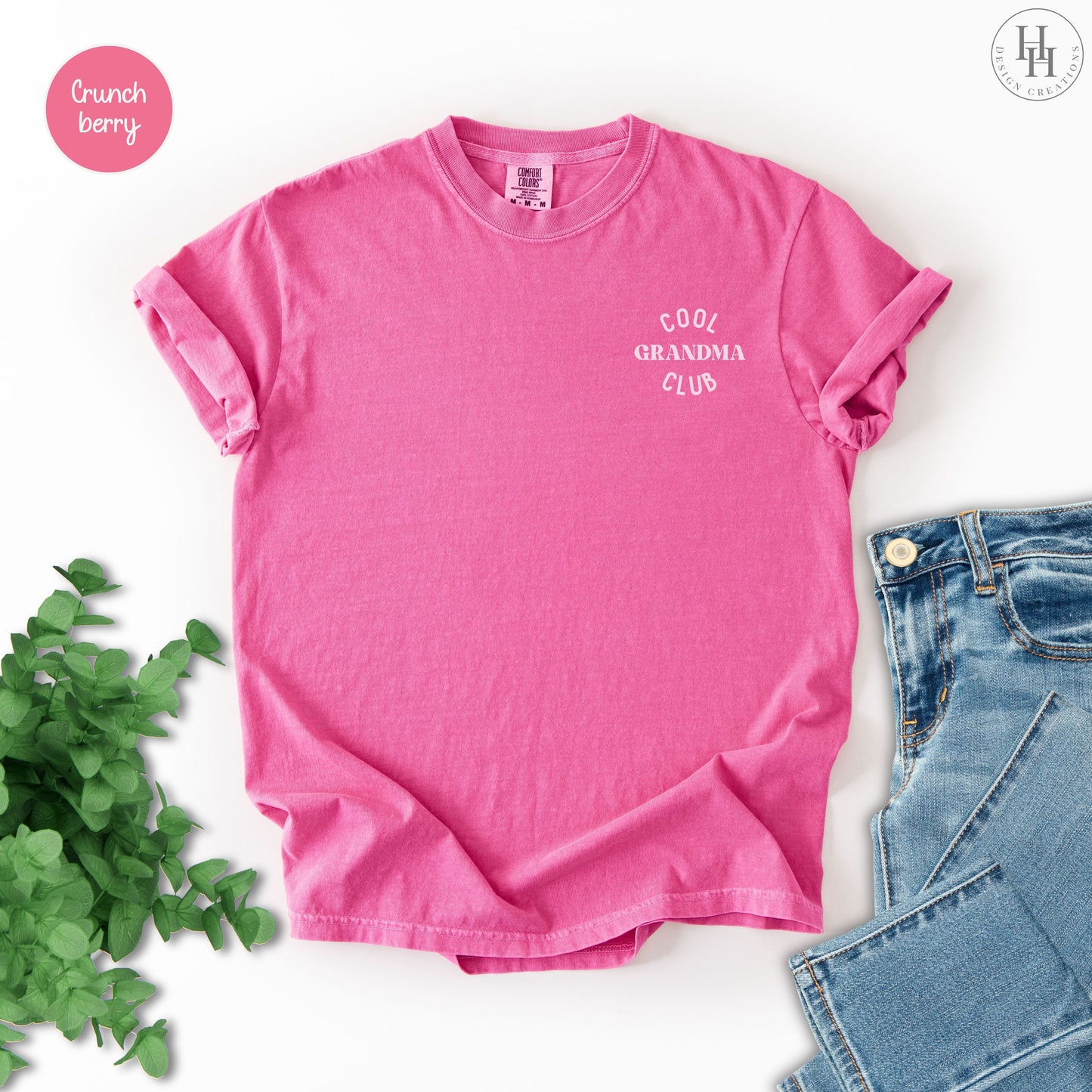 Pink t-shirt with 'faunt' definition text, placed on a white background with greenery and jeans.