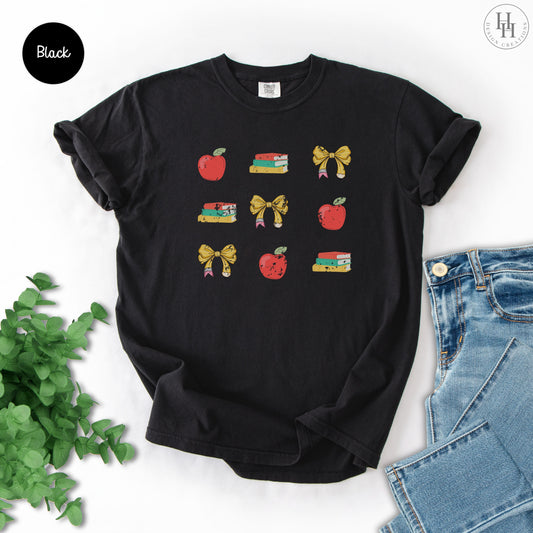 Black t-shirt with 'TEACHER' text on a white background with jeans and greenery.