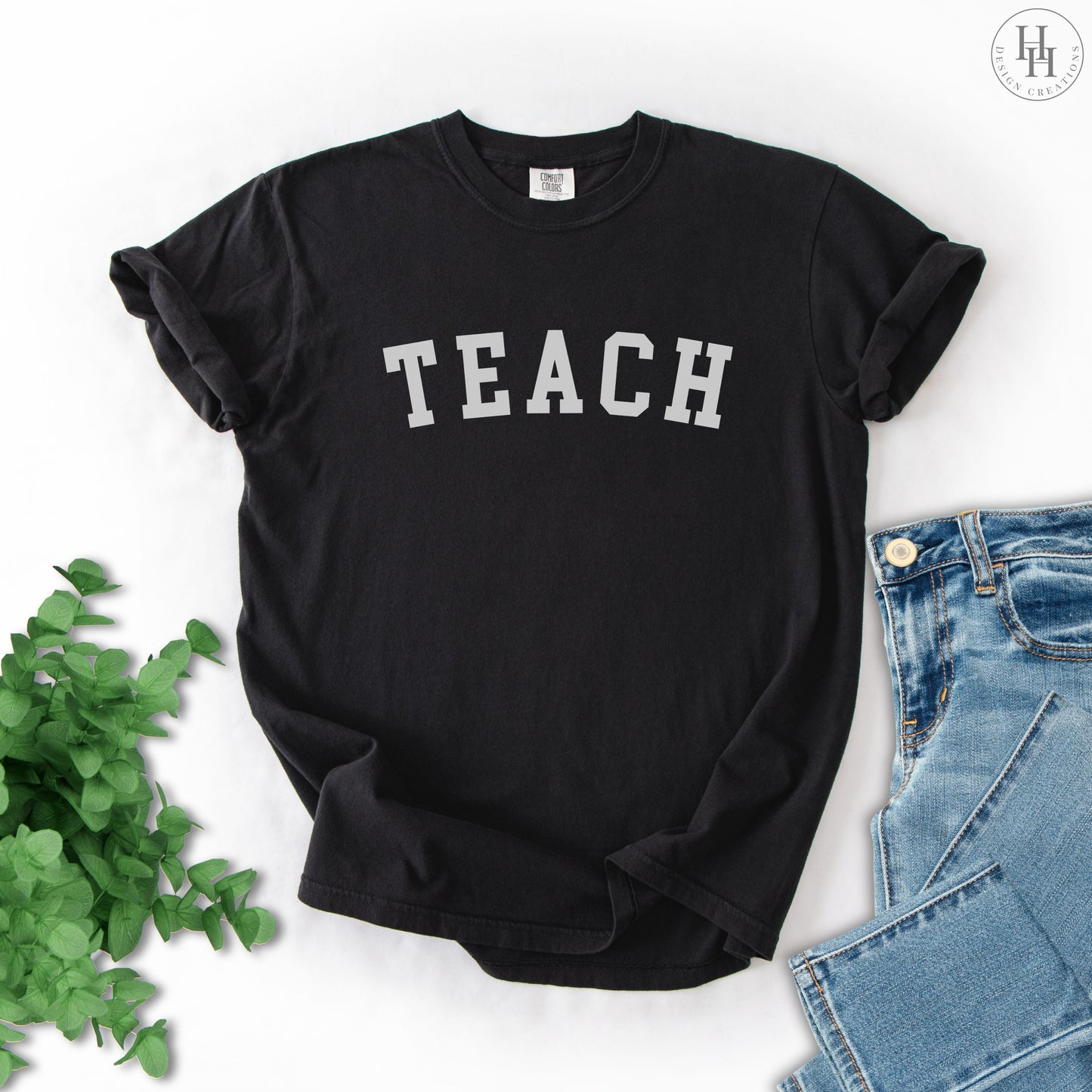 Black t-shirt with 'TEACH' text on a white background
